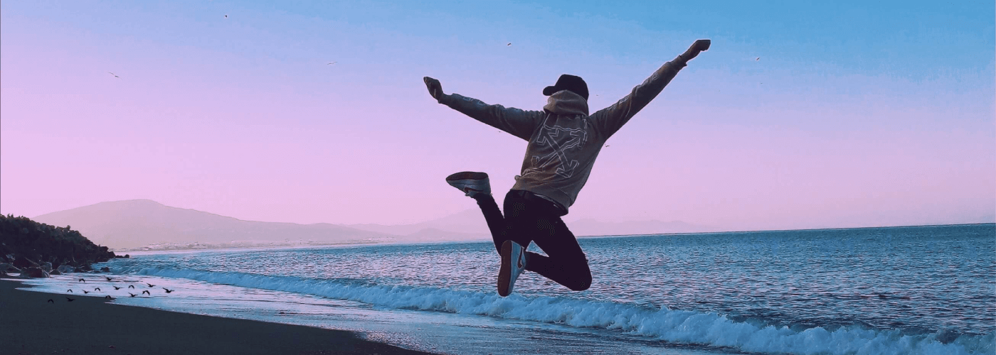 Happy Man Jumping On Beach