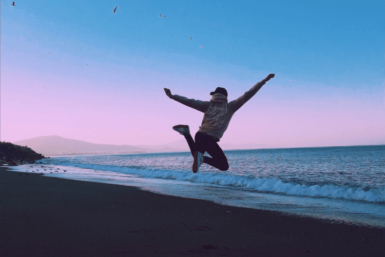Man Jumping For Joy On Beach