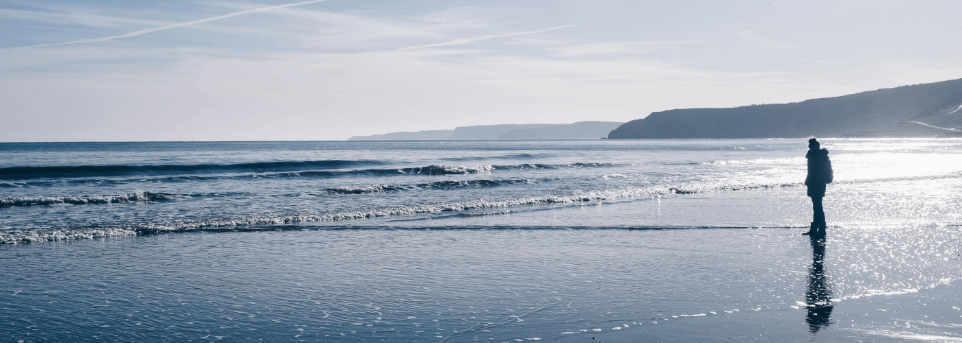 Woman On Beach Looking At Sea