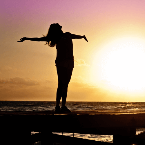 Happy Lady With Outstretched Arms By The Sea