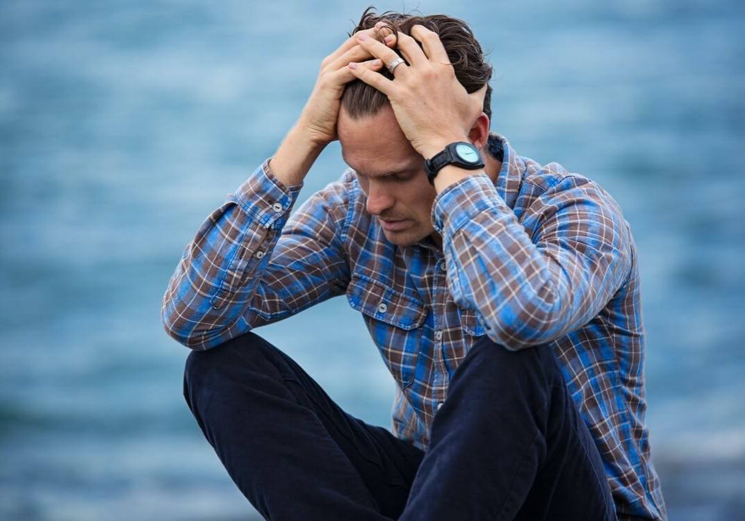 Stressed man with head in hands