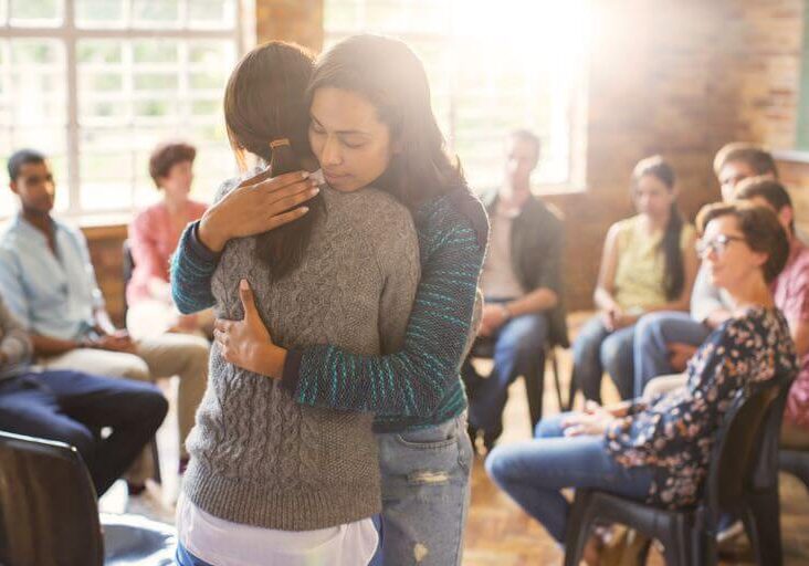 Women Hugging In Group Therapy Session